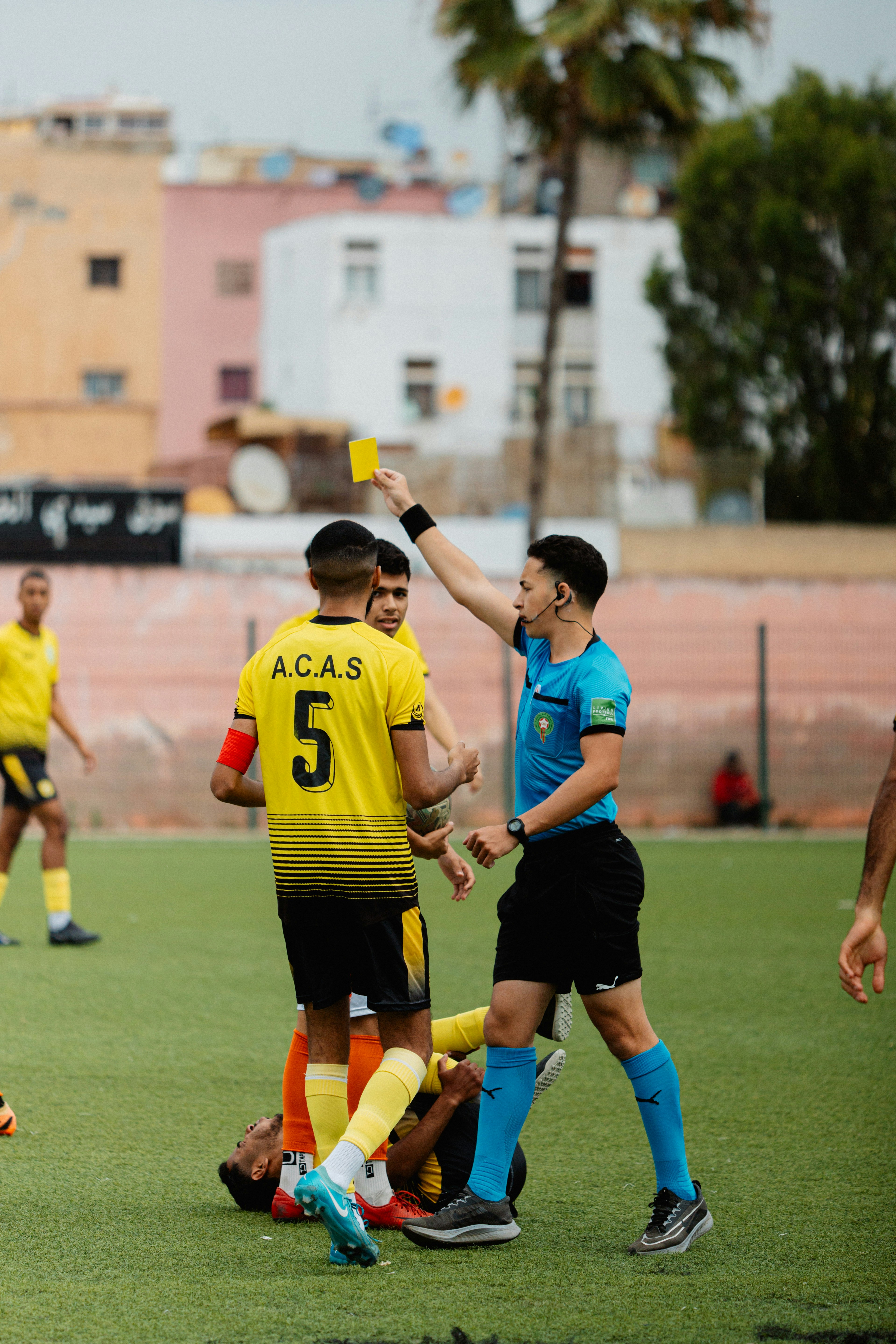 Referee holding a yellow card during a match
